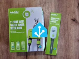 Pudełka produktów RainPoint: 2-strefowy sterownik nawadniania WiFi z hubem oraz inteligentny czujnik wilgotności gleby z nałożonym logo Home Assistant.